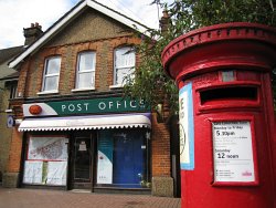 Photo of post box with poster attached saying 'Save Ware Road Post Office' 